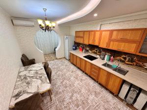a kitchen with wooden cabinets and a counter top at Poytakht 80 Apartments in Dushanbe