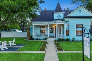 ein blaues Haus mit einem Schild davor in der Unterkunft Cloud 9 Pool Hot tub Fire pit Sleeps 18 in Fredericksburg