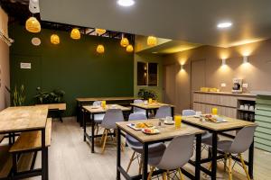a restaurant with tables and chairs and a kitchen at Poblado Guest House in Medellín