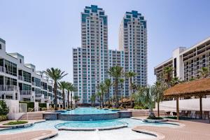 a resort swimming pool with palm trees and tall buildings at Sapphire Condominiums #806 in South Padre Island