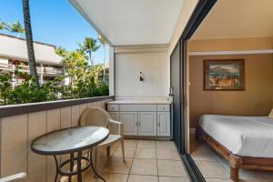 a small room with a bed and a table and a window at Waiakea Villas 4-124 in Hilo +23 photos