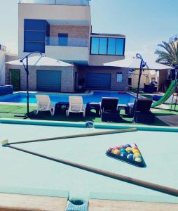 una mesa de billar con pelotas en una piscina en Tala DeadSea Villa en Sowayma