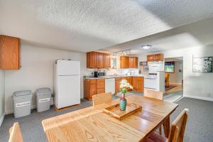a kitchen with a wooden table and a white refrigerator at Lakefront Family Retreat with Private Dock! in Rice Lake