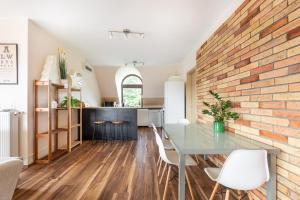 een keuken en eetkamer met een bakstenen muur bij Zen Harmony Hideaway - private luxury rooms with AC in long-term shared apartment in Boedapest
