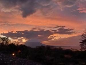 einen Sonnenuntergang mit einem Berg im Hintergrund in der Unterkunft Finca Magdalena Eco Lodge in Balgue