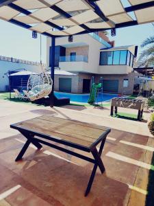 a picnic table with a swing and a playground at Tala DeadSea Villa in Sowayma