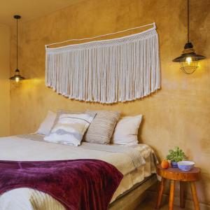 Hotel Hondo في لوس باريليس: غرفة نوم بسرير مع ستارة على الحائط