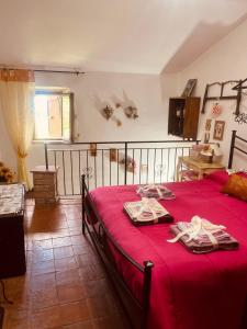1 dormitorio con cama roja y manta roja en Maison Amiata, en Montelaterone