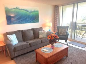 uma sala de estar com um sofá e uma mesa em Oceanview Retreat - Steps to the Beach and 2 Pools em Oceanside