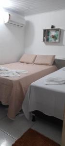 Hospedaria Temporarte في ببرانا: غرفة نوم بسريرين وصورة على الحائط