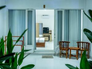 uma sala com um quarto com uma cama e cadeiras em Turtle House Lombok em Kuta Lombok