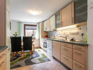 uma cozinha com armários de madeira e uma mesa e cadeiras em Am Inn Fluss em Langkampfen