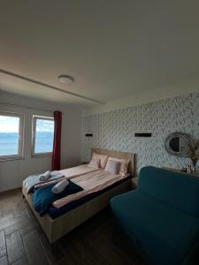 a bedroom with a bed and a blue couch at Vila Vista Magica Radozda in Struga