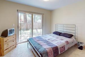 een slaapkamer met een bed, een tv en een raam bij Charles Charmer in South Lake Tahoe