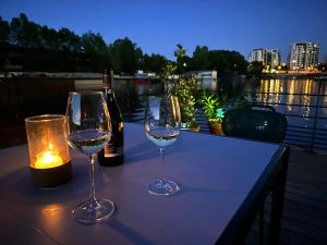 een tafel met twee wijnglazen en een fles wijn bij One of the kind Prague Houseboat Experience +BOAT in Praag