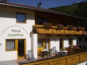 a building with a balcony with a table and chairs at Haus Josefine in Gerlos