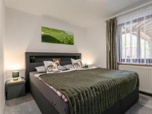 um quarto com uma cama grande e um cobertor verde em Am Inn Fluss em Langkampfen