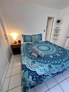 ein Schlafzimmer mit einem Bett mit einer blauen und weißen Decke in der Unterkunft Southwinds Inn by The Gold Nests in Hollywood