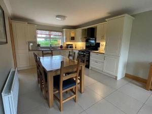 a large kitchen with a wooden table and chairs at Hazelwood House in Letterkenny