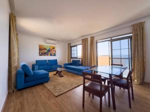 uma sala de estar com mobiliário azul e uma mesa de vidro em Oasis, Seaside em Dakar