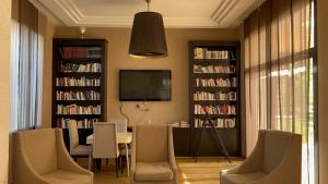 a living room with a table and chairs and book shelves at Villa orangeraie - private pool 35 mn Agadir in Agadir