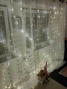 a window with a curtain with lights on it at Apartman K2 in Žarkovo