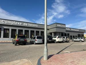 a building with cars parked in a parking lot at Complex Amazon Guercif in Guercif