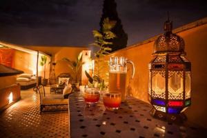 una mesa con dos vasos de cerveza y una linterna en Riad Moonlight & Spa, en Marrakech