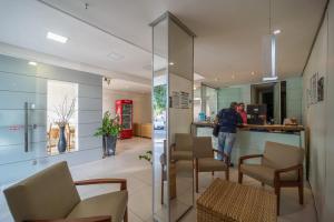 a lobby with a person standing at a counter at Lagoa Park Hotel in João Pessoa
