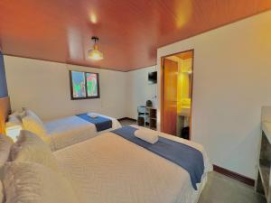Habitación de hotel con 2 camas y escritorio en Hotel Citadin Z10, en Guatemala