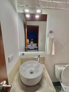 baño con lavabo blanco grande y aseo en Hotel Citadin Z10, en Guatemala