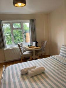a bedroom with a bed and a table and chairs at Daisy in Whetstone