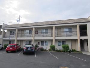 a hotel with cars parked in a parking lot at Redwood Creek Inn in Redwood City