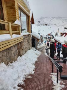 a snow covered sidewalk in front of a building at Rodas - Las Leñas in Las Lenas