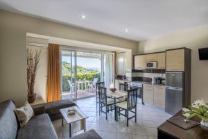 a kitchen and living room with a couch and a table at Yolanda Studios in Paralia Agias Foteinis