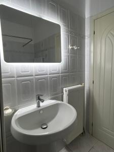 a white bathroom with a sink and a mirror at Villa in Ptolemaida 