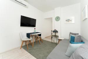 ein Wohnzimmer mit einem Sofa und einem Tisch in der Unterkunft Apartments Palma Rabac in Rabac