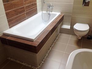 een badkamer met een bad, een toilet en een wastafel bij Apartmany Star in Liptovský Mikuláš