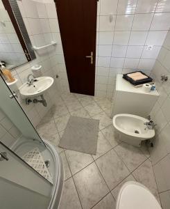 a bathroom with a sink and a toilet and a sink at Apartments by the sea Mali Losinj (Losinj) - 14844 in Mali Lošinj