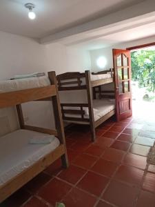 CalabazoにあるSantuario Tayrona Hostelの複数の二段ベッドとドアが備わる客室です。