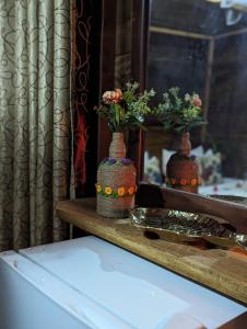 une table avec deux vases avec des fleurs dans l'établissement VISU VILLA hotel, à Habarana