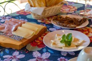 una mesa con dos platos de queso y una cesta de comida en Pousada Chalés Jardim das Bromélias - Visconde de Mauá, en Visconde De Maua