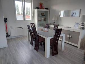 a dining room with a white table and chairs at Maison calme proche de la cité des loisirs in Amnéville +6 photos