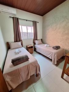 1 dormitorio con 2 camas y ventana en Casa Acerola - Vila de São Jorge, en São Jorge
