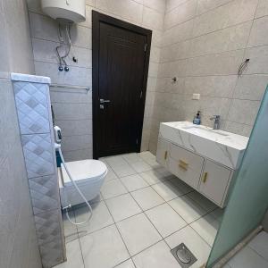 a bathroom with a toilet and a sink at Waves Chalet in Al Mazār