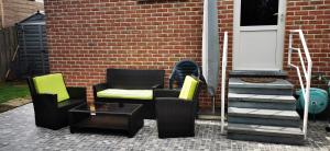 a patio with two chairs and a table next to a door at Studio équipé Brussels in Sint-Pieters-Leeuw