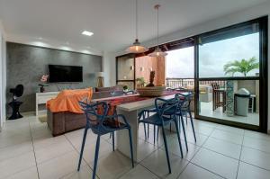 cocina y sala de estar con mesa y sillas en Cobertura Duplex Jacuzzi - Mediterranee Residence, en Aquiraz