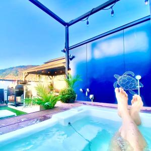 una persona en una piscina con una sombrilla en una bañera en Vacanza Resort, en Gifu