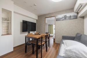 een woonkamer met een tafel en een bank bij SL601, 山手線-新宿2分, 5mins walk from shinokubo station free wifi in Tokyo