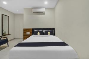 Collection O Hotel Swagath Pride في Mancherāl: غرفة نوم بسرير ابيض لحاف اسود وبيض